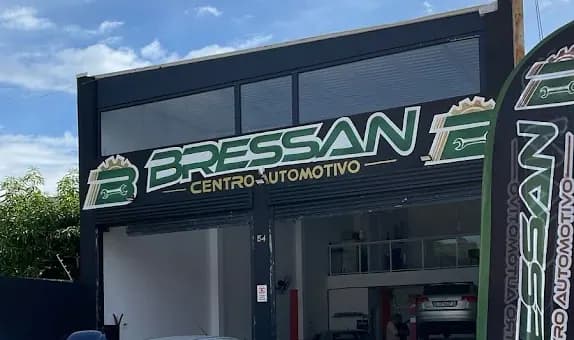 Entrada da Bressan Centro Automotivo vista da rua, com a bandeira da oficina